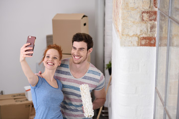 glückliches paar macht ein selfie beim umzug in neue wohnung