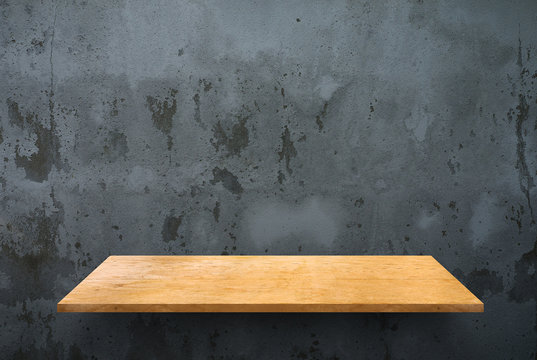 Empty wooden shelf on concrete wall texture