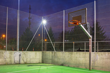 Basketball court illuminated at dusk