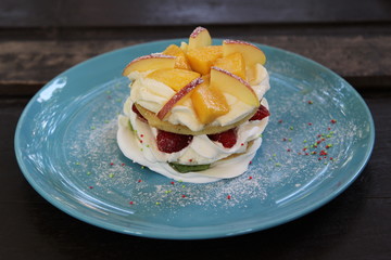 Mixed fruit pancakes on blue plate.