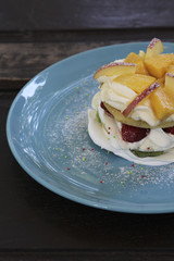 Mixed fruit pancakes on blue plate.