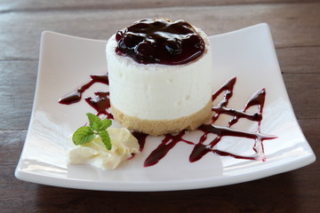 Blueberry cheesecake on white plate closeup.