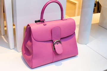 Pretty pink lady's handbag on the display window in the store