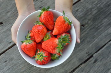 Strawberry in  bowl with hands