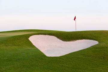 Heart shaped sand bunker in front of golf green