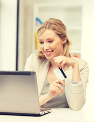 happy woman with laptop computer and credit card