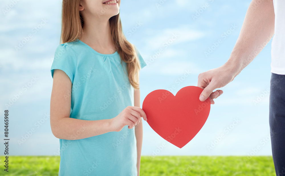 Wall mural close up of girl and male hand holding red heart