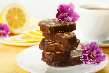 Pile of delicious chocolate cake slices decorated violet flowers