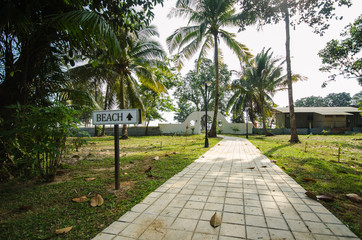 sidewalk pavement road leading to beach with sign