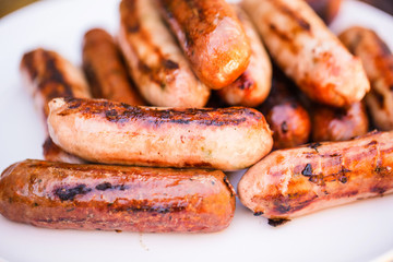 Barbecued beef and pork sausages on white plate