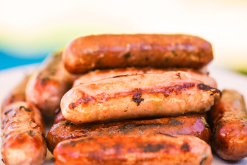 Barbecued beef and pork sausages on white plate