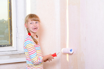 child paints the wall roller