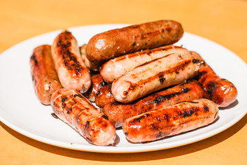 Barbecued beef and pork sausages on white plate