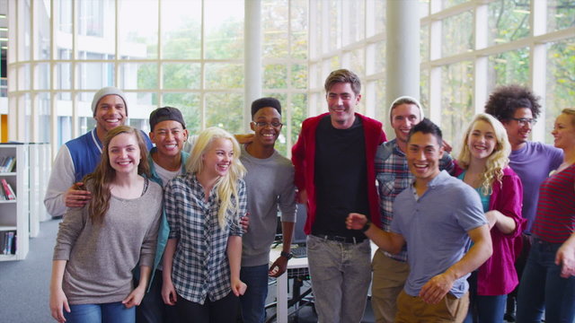 Portrait of a happy mixed ethnicity group of student friends in college library.