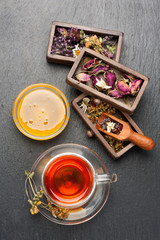 Herbal tea with honey, dried herbs and flowers. top view