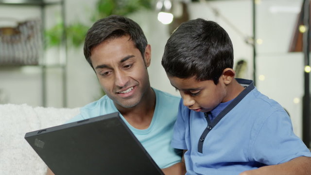 Father and son browsing the internet on a laptop computer