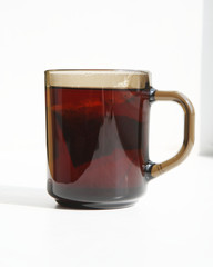 A cup of tea on the windowsill in the sunlight.