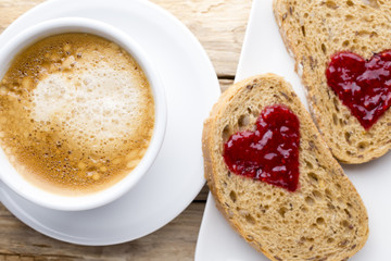 Fresh coffee. Grain slice of bread with jam heart shape.