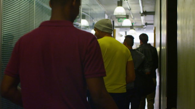 Young student group walking through the hallway in modern college building