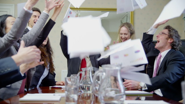 Ecstatic business team in elegant office throw documents and papers into the air
