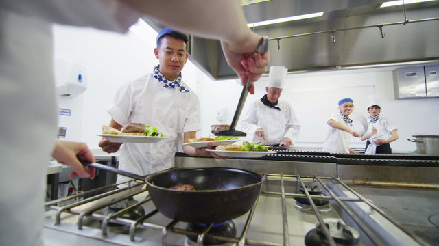 Mixed ethnicity team of professional chefs preparing food ready for service