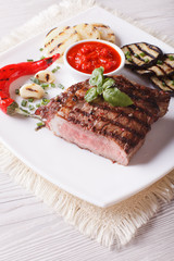 beef steak and grilled vegetables close-up on a plate. vertical