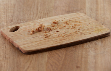 Bread crumbs on cutting board on wooden background