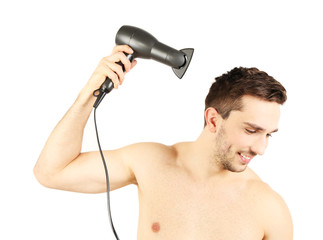 Handsome young man blow drying his hair isolated on white