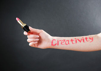 Word creativity written on female hand on black background