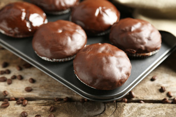 Tasty homemade chocolate muffins on wooden table