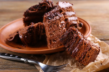 Slices of tasty chocolate cake on plate on table close up