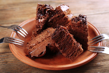 Slices of tasty chocolate cake on plate on table close up
