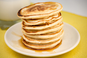 Fototapeta na wymiar Hot pancakes with maple syrup and milk