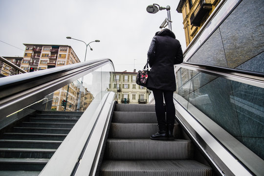 ragazza su scala mobile esce dalla metropolitana