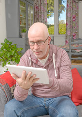 a man with glasses looking at a tablet