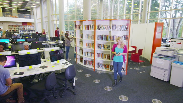 Diverse student group working in the library of large modern university building