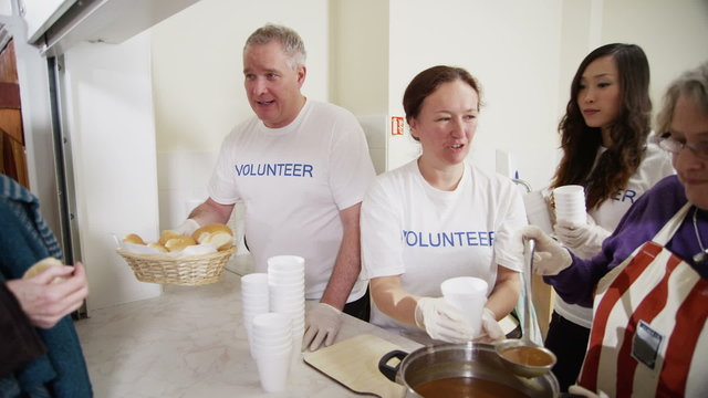 Soup kitchen volunteers help to feed the homeless