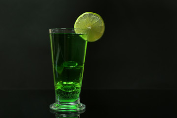 Flaming green cocktail on dark background