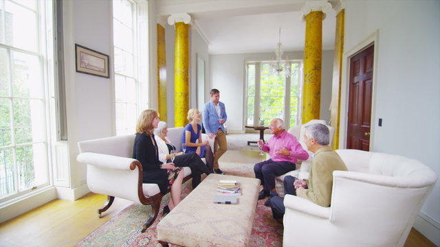 Three generations of a family socializing and drinking champagne in elegant home