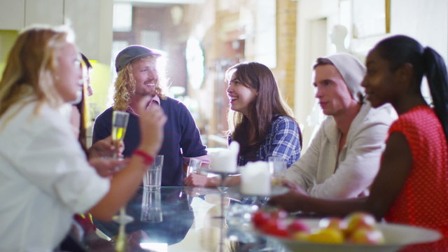 Happy diverse group of friends socializing and chatting over drinks