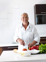 man cooking at home preparing salad in kitchen