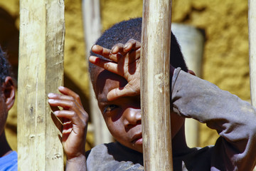 Very shy african boy with shadow on his face, poverty in Madagas
