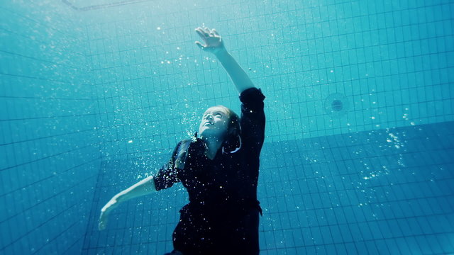 Drowning underwater businesswoman struggling to make it out of deep water
