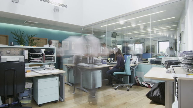 Time lapse of creative young professionals at work in busy modern office