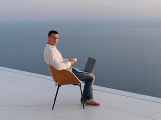 relaxed young man at home on balcony