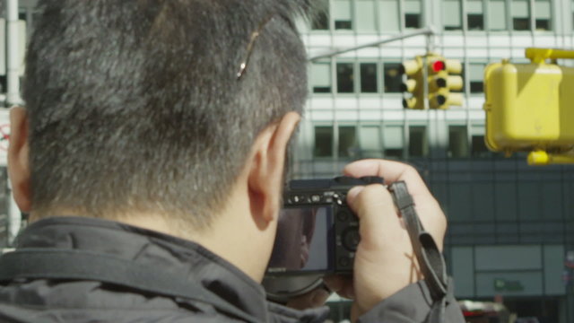 Anonymous male tourist taking photographs on a New York City street