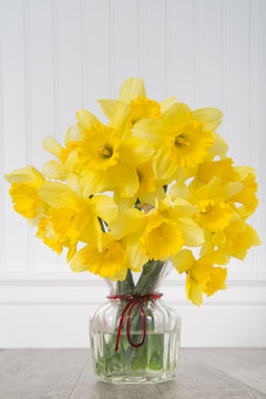 Daffodils in a vase in rustic setting - vertical