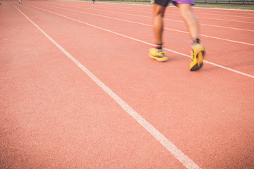 Running track with blur of runner feet in stadium