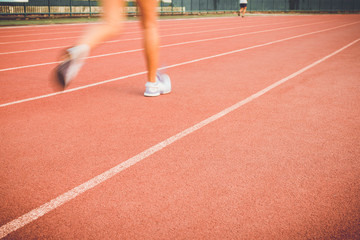 Running track with blur of runner feet in stadium