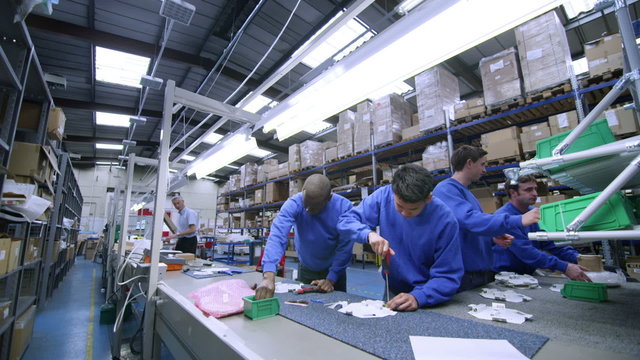 Male factory staff of mixed ethnicity working together on an assembly line